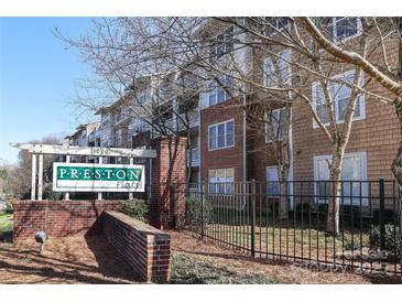 Preston Flats community sign made of brick with nicely landscaped entrance and updated buildings in the background at 1000 E Woodlawn Rd # 110, Charlotte, NC 28209