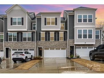 Beautiful townhome exterior boasts stone accents, gray siding and a two-car garage at 2061 Dornoch Rd, Fort Mill, SC 29708