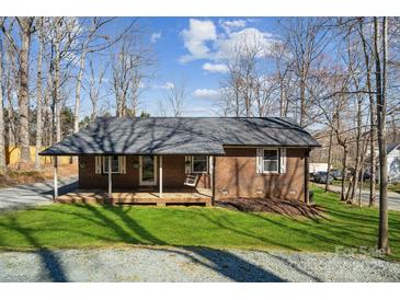 Charming brick home featuring a covered porch and swing, complemented by a well-manicured lawn at 259 Unionville Indian Trail W Rd, Indian Trail, NC 28079