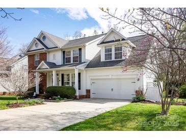 Charming two-story home featuring a well-manicured lawn, blossoming trees, and an attached two-car garage at 3329 Brownes Creek Rd, Charlotte, NC 28269