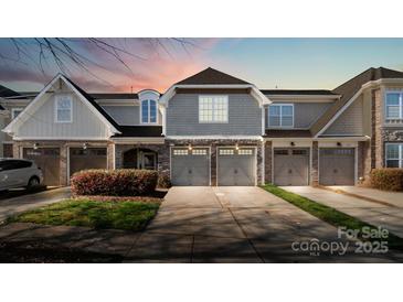 Charming townhome showcasing a well-manicured lawn, private garage, and appealing architectural details at 8534 Loxton Cir, Charlotte, NC 28214