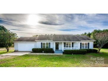 Charming single-story home with manicured lawn, inviting front porch, and attached garage at 9450 Paul Payne Store Rd, Stony Point, NC 28678