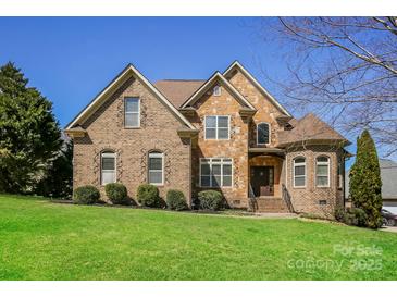 Beautiful brick and stone home featuring manicured lawn, mature landscaping and inviting architectural details at 1125 Bugle Ln, Newton, NC 28658