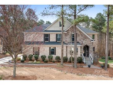 Charming two-story home with a stone and brick exterior and beautifully landscaped front yard at 147 Belfry Loop, Mooresville, NC 28117