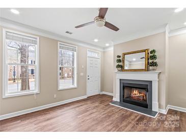 Inviting living room with a cozy fireplace and plenty of natural light from two large windows at 163 Singleton Rd, Mooresville, NC 28117
