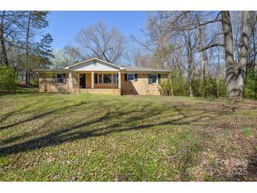 Charming single-story home with a brick facade and a covered front porch, surrounded by a lawn at 2519 Arnold Dr, Monroe, NC 28110