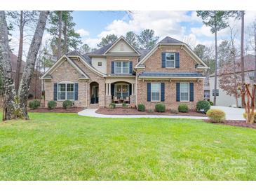 Beautiful brick and stone home featuring lush green lawn, manicured shrubs, and sidewalk to covered front porch at 303 Ridge Reserve Dr # 29, Clover, SC 29710