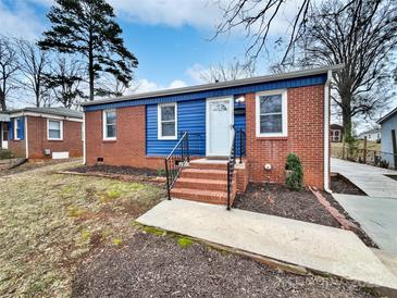 Charming single-story home featuring a brick facade, blue accent paneling, and a welcoming front entrance at 325 Oregon St, Charlotte, NC 28208