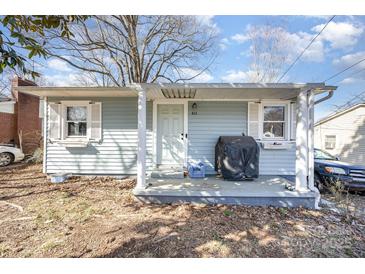 Charming single-story home featuring light blue siding and a cozy front porch area at 421 N Tradd St, Statesville, NC 28677