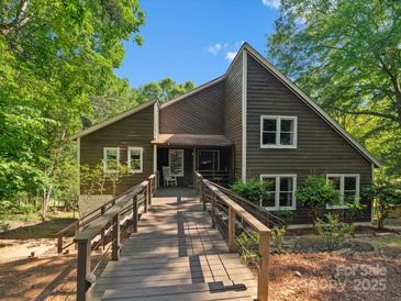 Charming home featuring a spacious wooden deck, beautiful landscaping, and a welcoming entrance at 5084 Mariana Ct, Tega Cay, SC 29708