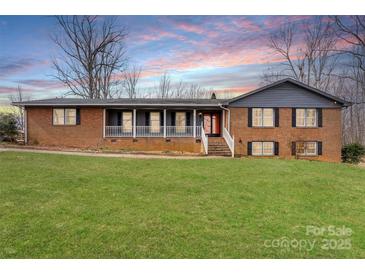 Charming brick home boasts a covered front porch and a spacious, well-manicured lawn at 822 Bethlehem Rd, Kings Mountain, NC 28086