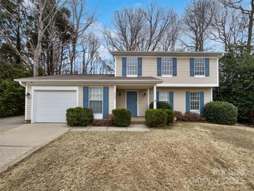 Charming two-story home featuring a garage, blue shutters, and well-manicured landscaping at 10301 Shelter Rock Ct, Charlotte, NC 28214