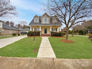 Charming two-story home with a well-manicured lawn, inviting walkway, and classic architectural details at 104 Tarrington Dr, Statesville, NC 28625
