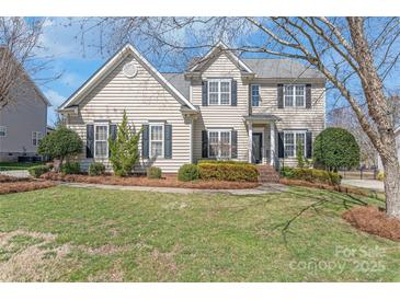 Charming two-story home featuring a well-maintained lawn and complemented by mature trees and manicured shrubbery at 10615 Persimmon Creek Dr, Mint Hill, NC 28227