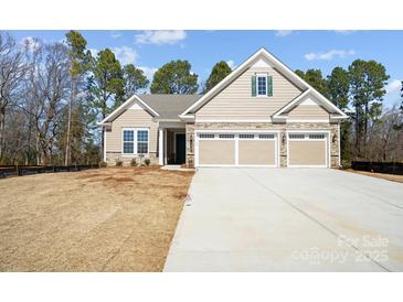 Newly constructed home with stone detailing, a three-car garage, and a well-manicured lawn at 13101 Cozy Ct, Charlotte, NC 28215