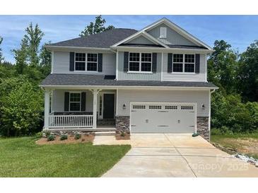 Charming two-story home featuring a covered front porch, two-car garage, and landscaped front yard at 149 High Rock Ct # 02, Statesville, NC 28677