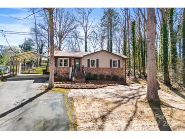 Charming brick home with a covered parking area and landscaped front yard at 210 E Poplar St, Stanley, NC 28164