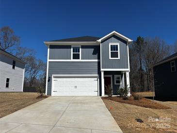 Charming two-story home with a grey exterior, white garage door, and a well-manicured lawn on a sunny day at 309 Alden Ct, Shelby, NC 28152