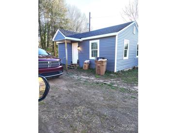 Cozy single-story home featuring blue siding, a covered porch, and well-lit entrance at 336 Hudson St, Shelby, NC 28150