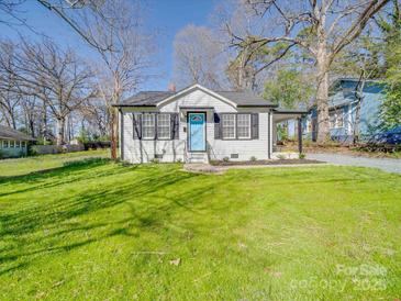 Charming single-story home featuring a bright blue door and a well-maintained lawn at 407 E Talleyrand St, Monroe, NC 28112