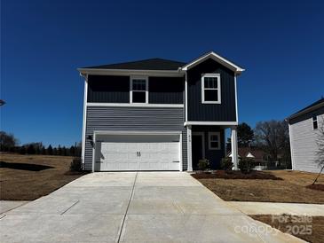 Two-story home featuring gray siding, a white garage door, and a well-maintained concrete driveway at 410 Luna Ln, Shelby, NC 28152
