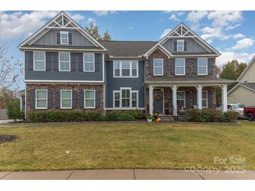 Two story home with stone accents, showcasing a charming curb appeal and inviting entrance at 4660 Ardmore Ln, Harrisburg, NC 28075