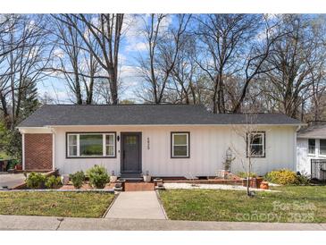 Charming single-story home featuring a white exterior, gray accents, and a welcoming brick pathway at 4820 Valley Stream Rd, Charlotte, NC 28209