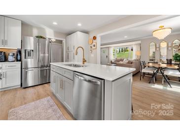 Bright, open-concept kitchen with stainless steel appliances and a view to the living and dining areas at 4820 Valley Stream Rd, Charlotte, NC 28209