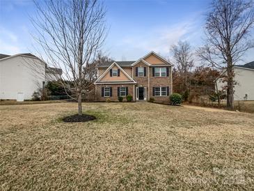 Traditional two-story brick home with black shutters and manicured lawn at 6084 Diamond Pl, Harrisburg, NC 28075