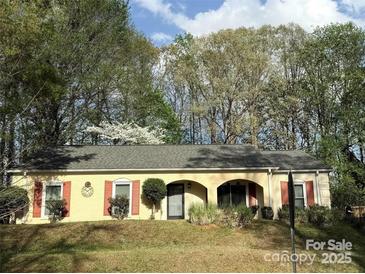 Charming single-story home features a well-manicured lawn and mature trees at 6721 Old Post Rd, Charlotte, NC 28212