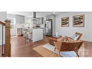 Open kitchen featuring stainless steel appliances, island with seating, and natural light at 6914 Idlewild Rd, Charlotte, NC 28212