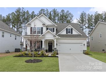 Charming two-story home featuring a two-car garage and a beautifully landscaped front yard at 141 Rhuidean Ct, Troutman, NC 28166