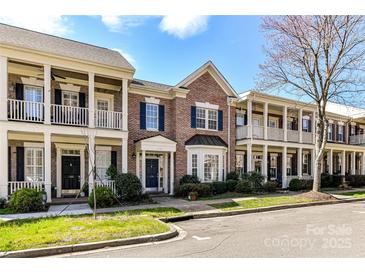 Charming brick townhouses featuring covered porches and landscaped front yards create a welcoming community ambiance at 178 Harper Lee St, Davidson, NC 28036