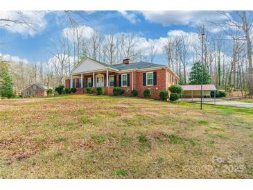 Classic brick home featuring a wide porch with stately columns and a well-manicured lawn at 406 Forest Dr, York, SC 29745