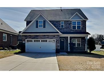 Two-story home with stone accents, a two-car garage, and a well-manicured lawn at 620 Weyburn Nw Dr, Concord, NC 28027