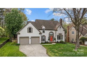 Charming two-story home with a well-manicured lawn, two-car garage, and inviting orange front door at 6319 High Creek Ct, Charlotte, NC 28277