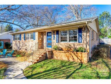 Charming brick home with blue door and shutters on a sunny day at 6956 Oakstone Pl, Charlotte, NC 28210