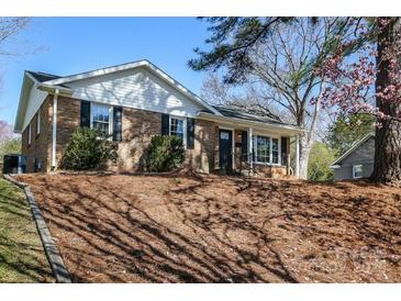 Inviting brick home with black shutters and budding trees at 7124 Brynhurst Dr, Charlotte, NC 28210