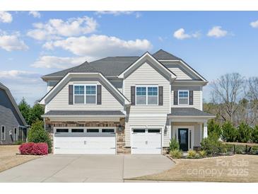 Two-story home with stone accents, two-car garage, well maintained landscape, and inviting curb appeal at 8310 Sandstone Crest Ln, Indian Land, SC 29707