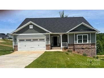 Charming single-story home featuring a two-car garage, stone accents and a welcoming front porch at 111 High Rock Ct # 10, Statesville, NC 28677
