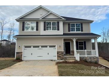 Charming two-story home featuring a two-car garage, stone accents, and a welcoming front porch at 121 High Rock Ct # 08, Statesville, NC 28677