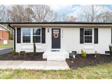 Charming brick home featuring a black front door with a decorative wreath and manicured landscaping at 2318 Knight Dr, Gastonia, NC 28052