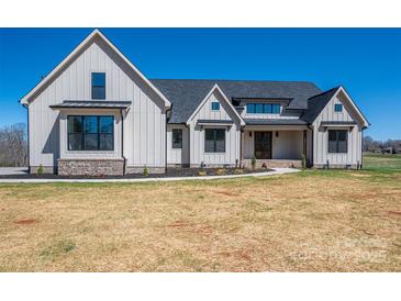 Stunning two-story modern farmhouse with white siding, black trim, and a well-manicured lawn at 2321 Ivey Church Rd, Maiden, NC 28650