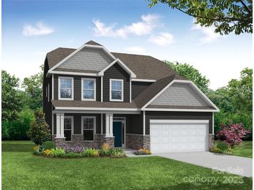 Charming two-story home with stone accents, white trim, a two-car garage, and a well-manicured lawn at 2789 Ashton Park Ln # 68, Monroe, NC 28110