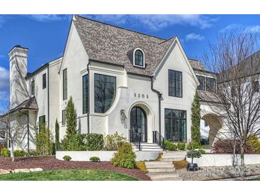 A stunning two-story home featuring a stucco facade, concrete steps, professional landscaping, and a charming arched entryway at 3203 Maymont Pl, Charlotte, NC 28205