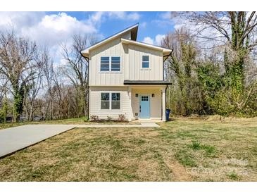 Inviting two-story home featuring a light exterior, blue front door, and well-maintained lawn at 709 Catawba St, Lincolnton, NC 28092