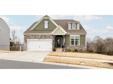 Charming two-story home with stone accents, a well-manicured lawn, and a two-car garage at 8828 Powder Works Dr, Huntersville, NC 28078