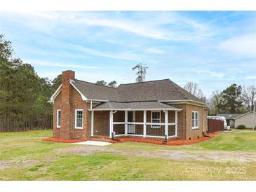 Charming brick home featuring a cozy front porch and well-maintained lawn at 2005 Douglas Rd, Lancaster, SC 28720