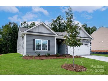 Charming single-story home with gray siding, stone accents, well-manicured lawn, and an attached two-car garage at 3512 Narrow Ln, Charlotte, NC 28215