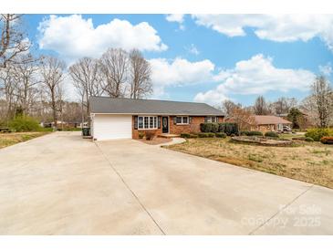 Charming brick ranch home featuring a spacious driveway and attached garage at 4014 Linwood Rd, Gastonia, NC 28052